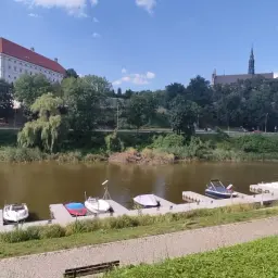 Widok na Wisłę z łodziami przy pomoście. W tle zamek i kościół, malownicze okolice Sandomierza atrakcje dla turystów.